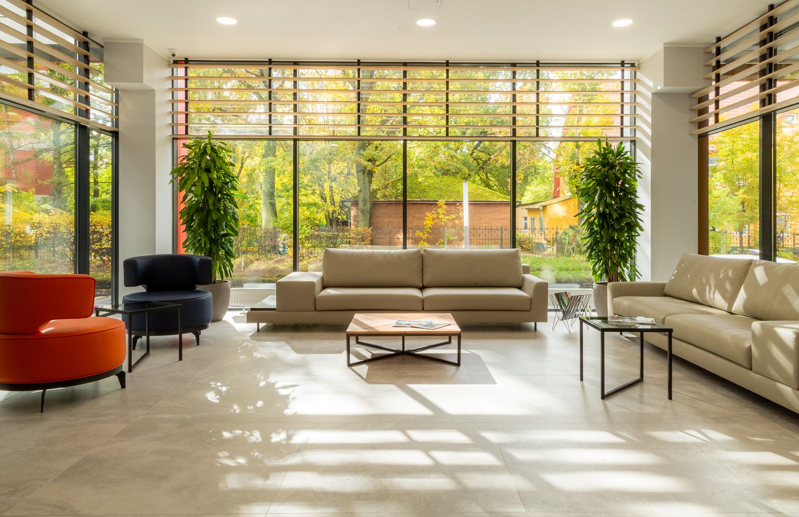 Bright furnished living area with large windows overlooking greenery